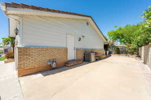 View of property exterior with brick siding and a fenced backyard