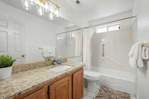 Full bath featuring vanity, light tile patterned flooring, and shower / bath combo with shower curtain