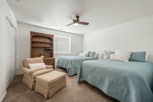Bedroom with carpet flooring, a closet, a ceiling fan, and a textured ceiling