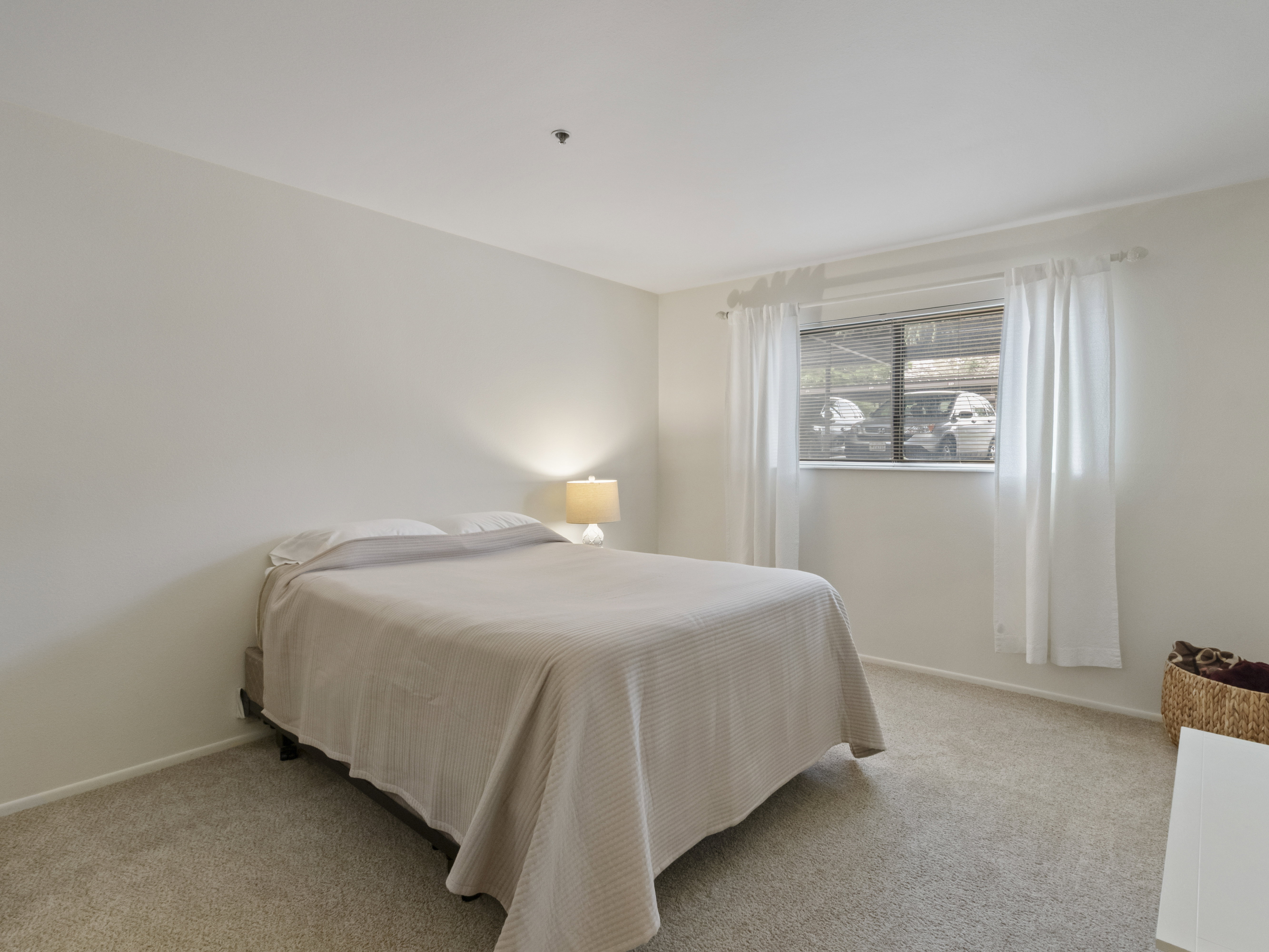 Bedroom featuring light carpet and baseboards