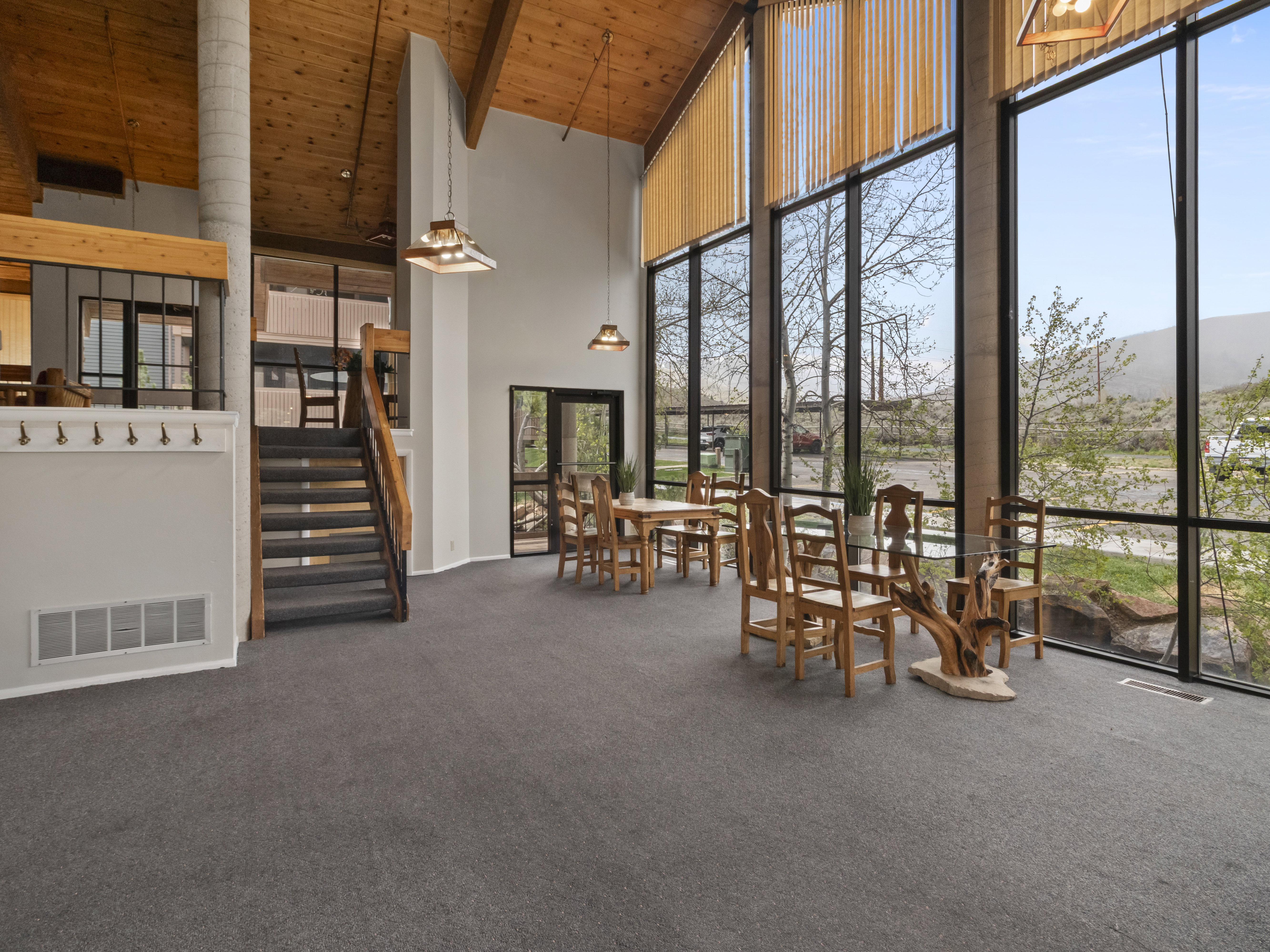 Dining room with dark carpet and a high wooden ceiling
