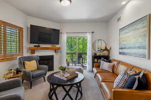 Carpeted living area with plenty of natural light and a fireplace