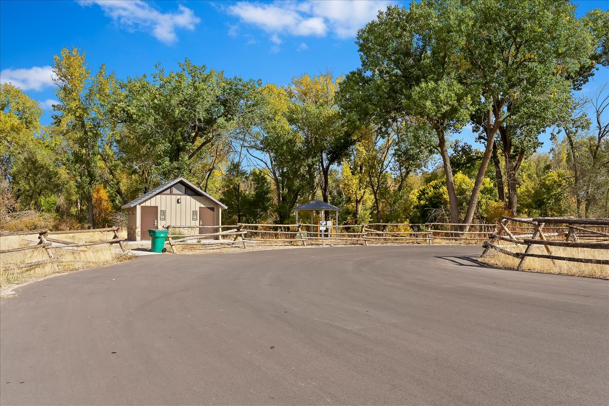View of asphalt street featuring view of wooded area