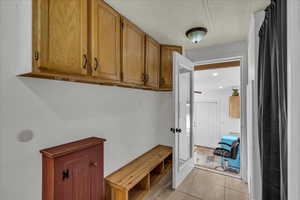 Mudroom featuring light tile patterned floors and a textured ceiling
