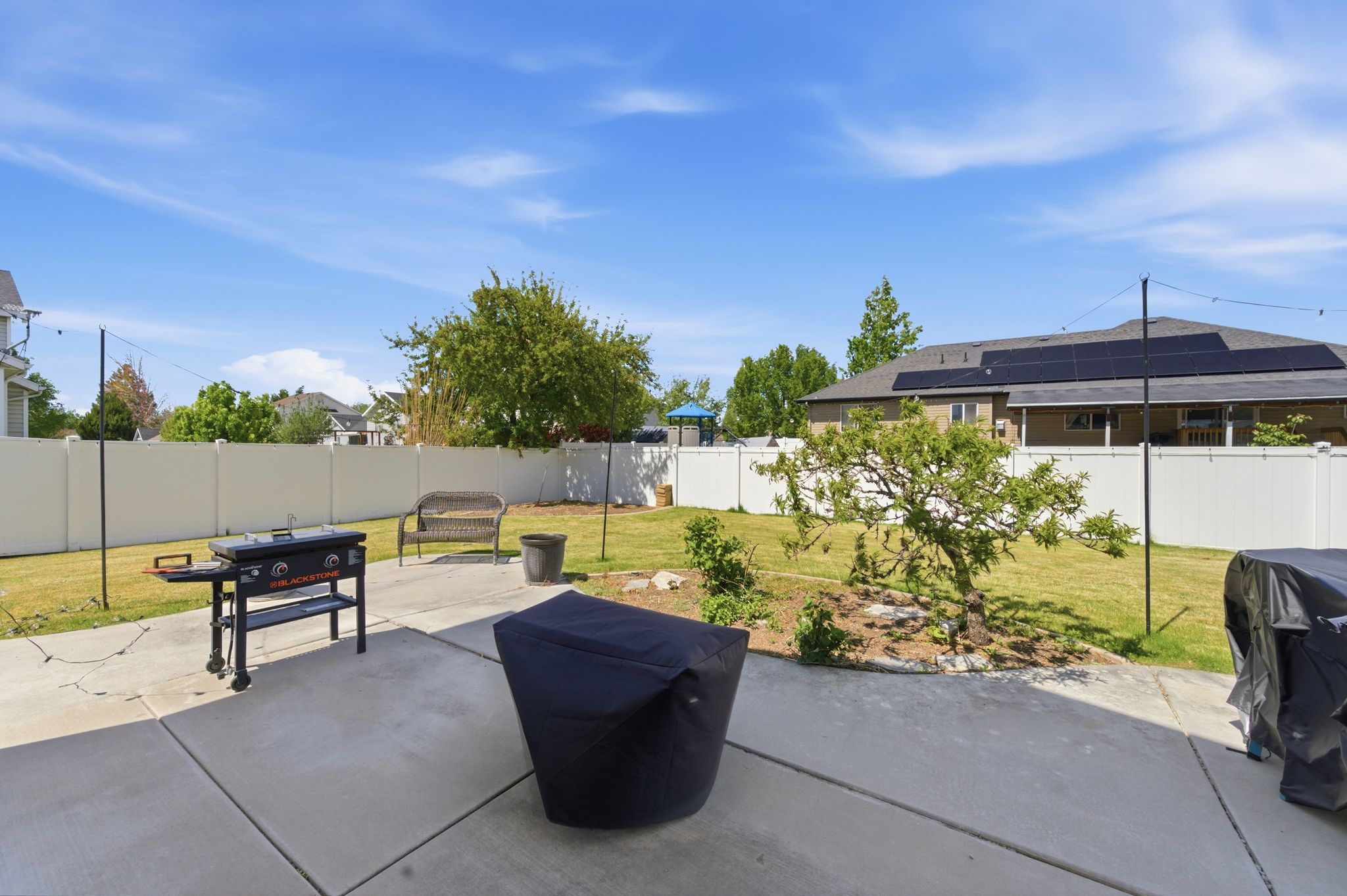 Fenced backyard featuring a patio and area for grilling