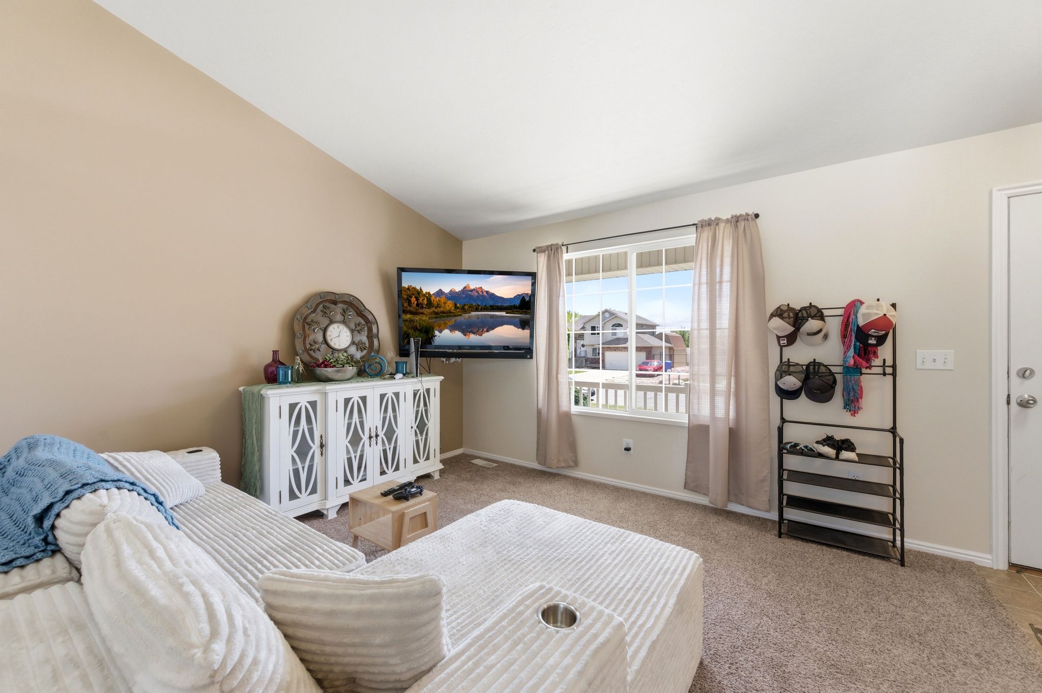 Bedroom featuring light carpet and vaulted ceiling
