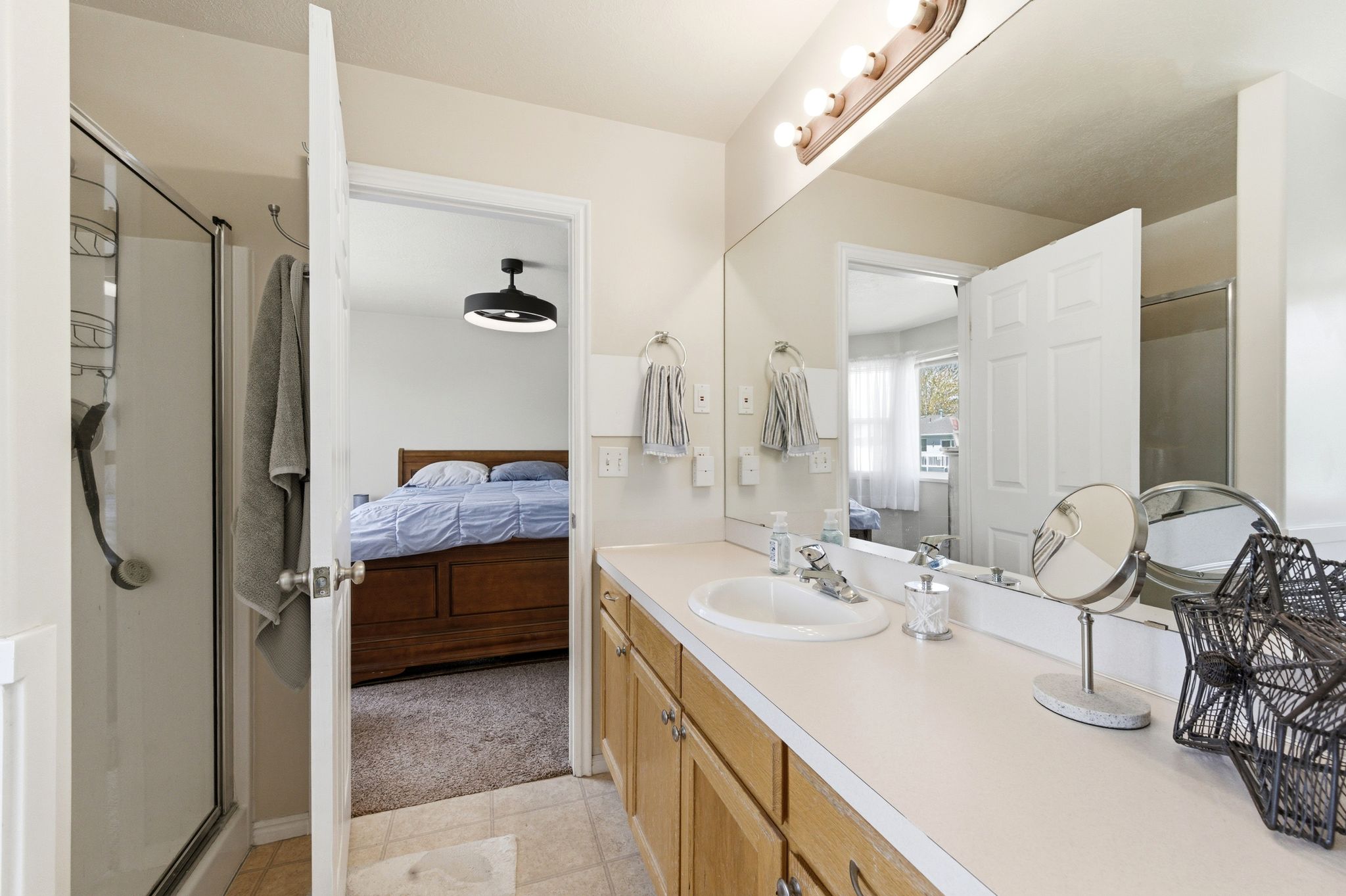 Bathroom featuring a stall shower, vanity, and connected bathroom