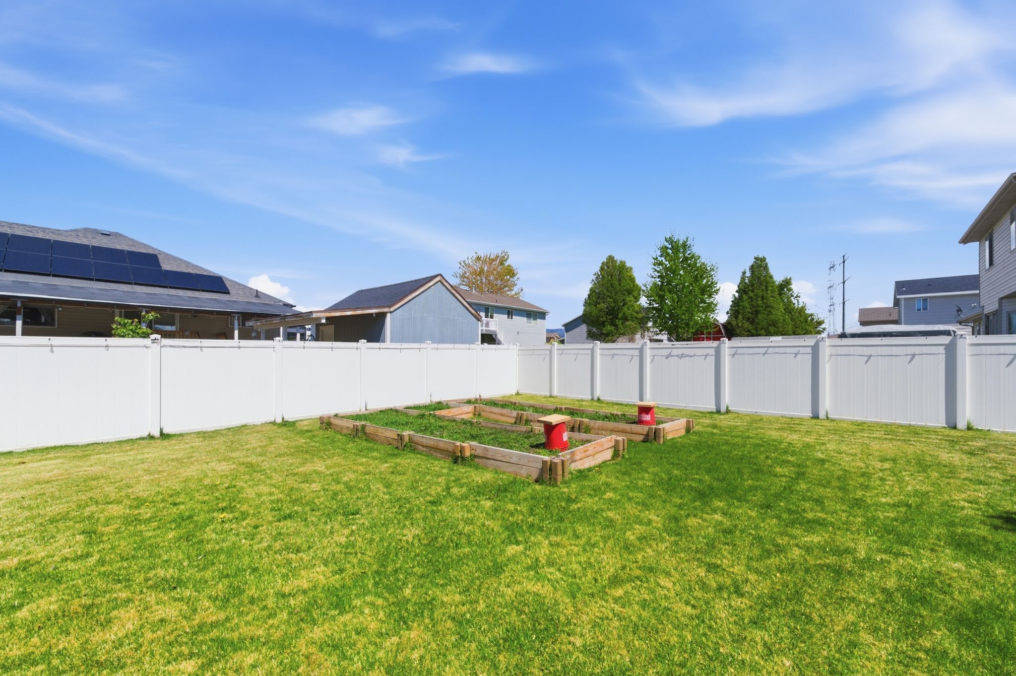 Fenced backyard with a vegetable garden