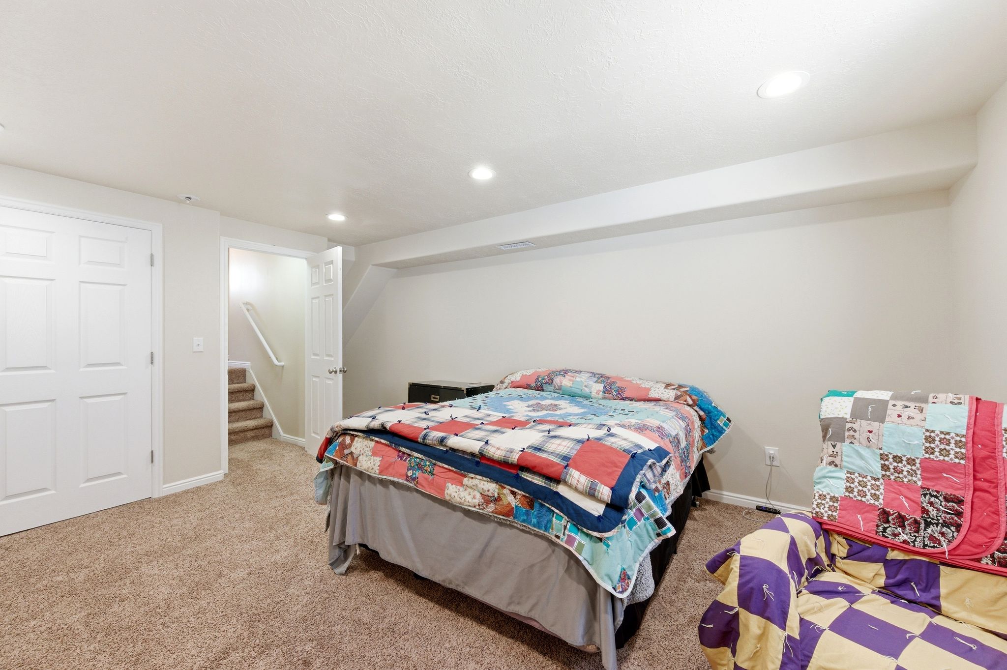 Bedroom with light colored carpet and recessed lighting