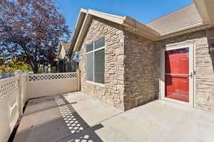 Property entrance with stone siding and a shingled roof