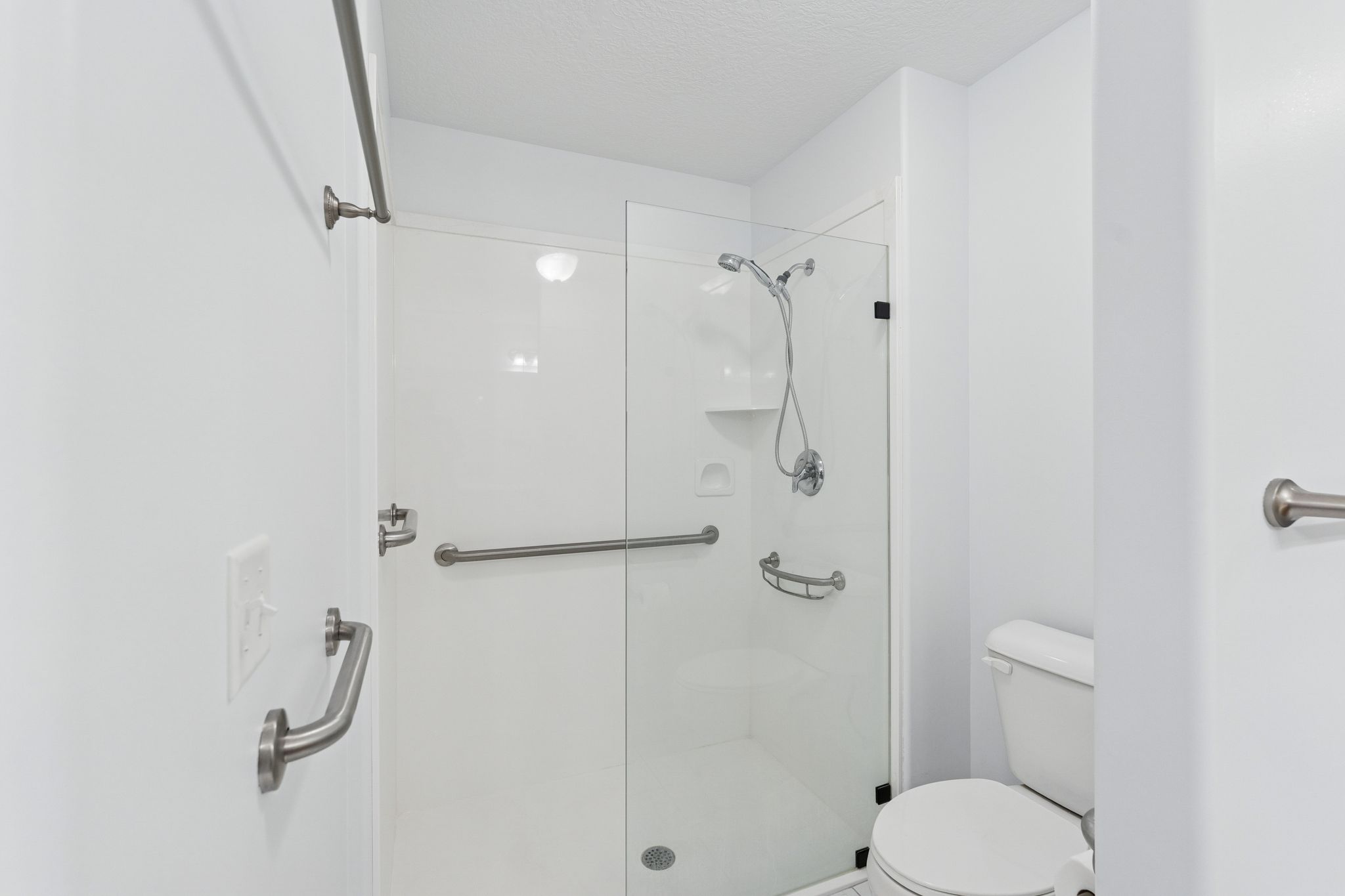 Full bath featuring a stall shower and a textured ceiling