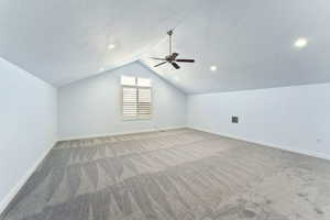 Additional living space with carpet floors, a textured ceiling, and ceiling fan