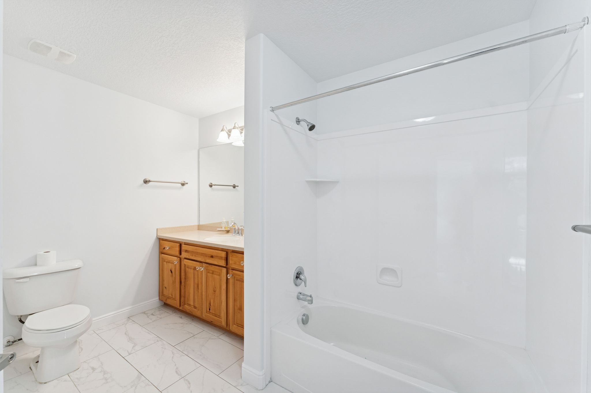 Full bathroom with vanity, shower / washtub combination, light marble finish flooring, and a textured ceiling