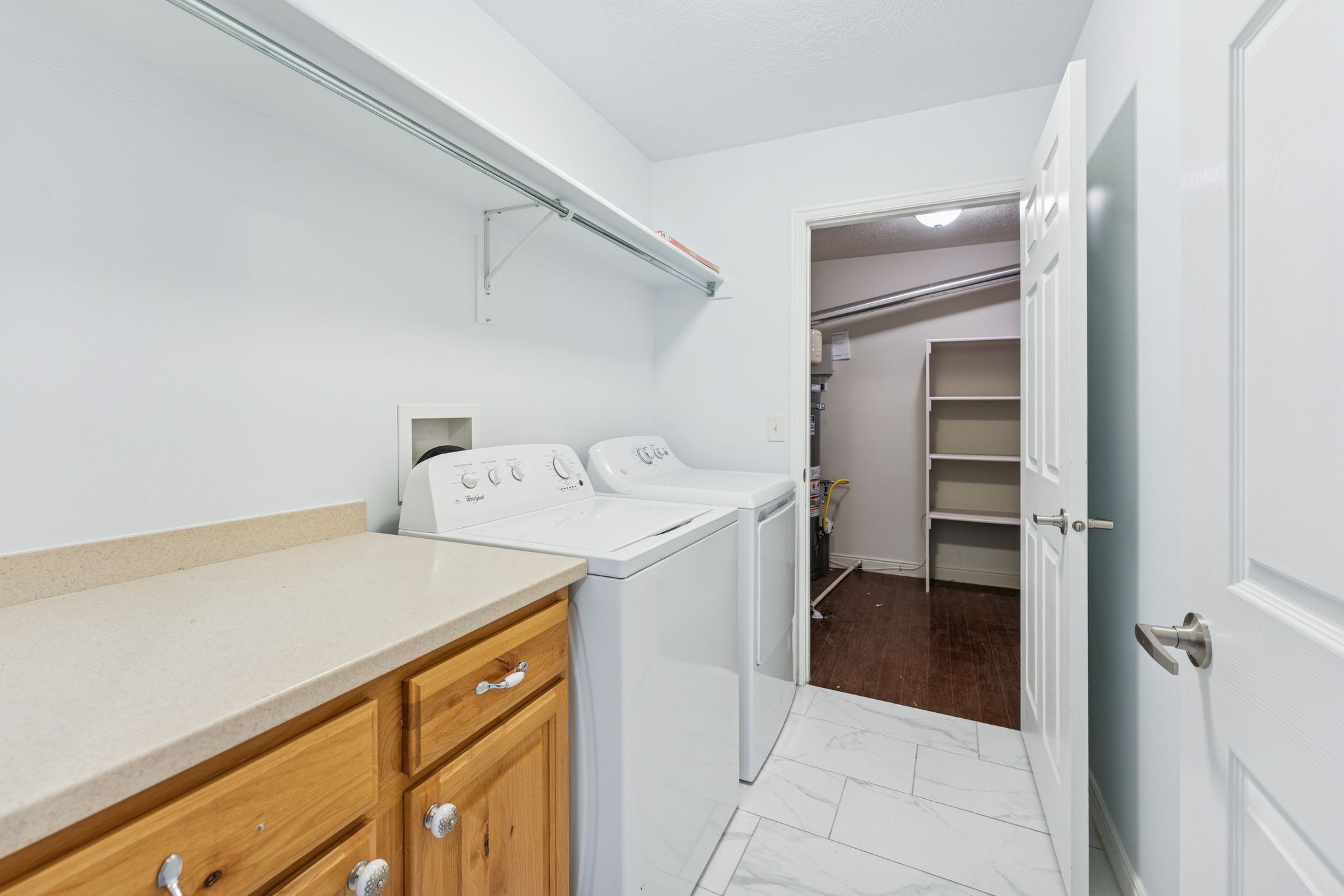 Laundry area with washing machine and clothes dryer and light marble finish flooring