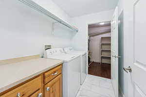 Laundry area with washing machine and clothes dryer and light marble finish flooring