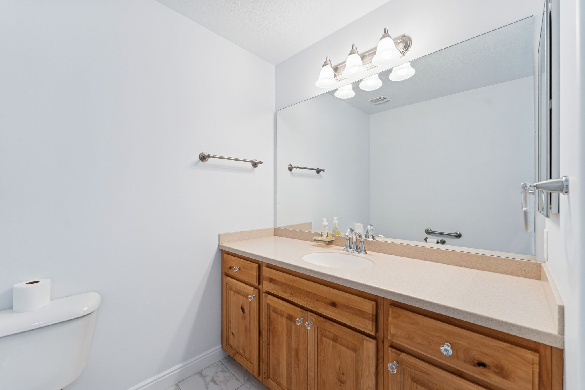 Half bathroom featuring vanity and light marble finish floors