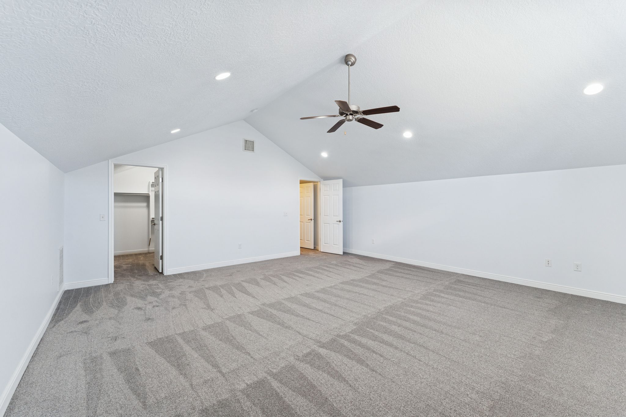 Bonus room featuring a ceiling fan, light carpet, and a textured ceiling