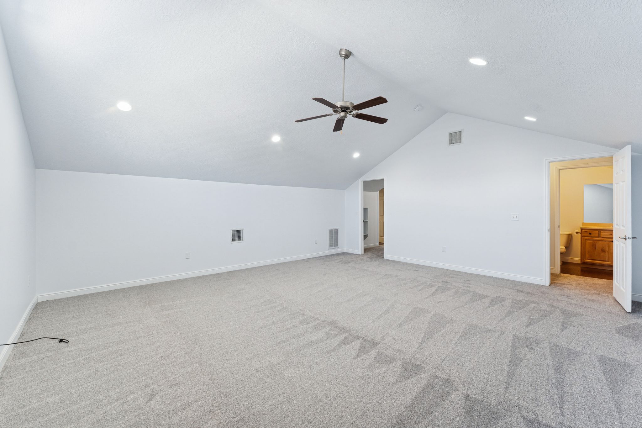 Bonus room with light colored carpet, ceiling fan, and recessed lighting