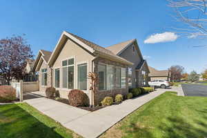 View of home's exterior featuring stone siding, stucco siding, and roof with shingles