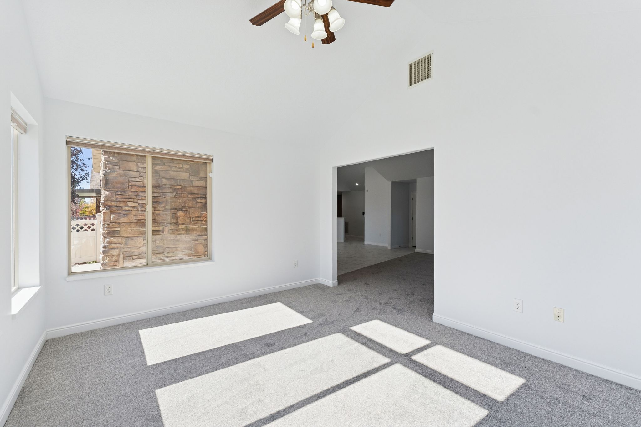 Unfurnished room with carpet flooring, a ceiling fan, and lofted ceiling