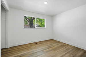 Unfurnished bedroom with light wood-style flooring, a closet, and a textured ceiling