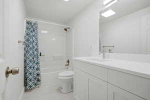 Bathroom with vanity, shower / bath combination with curtain, and light tile patterned floors