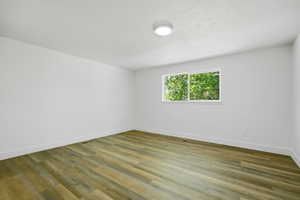 Empty room featuring wood finished floors and a textured ceiling