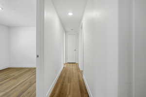 Hallway featuring light wood-style flooring and recessed lighting