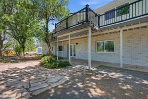 Back of house featuring a patio area, brick siding, and a balcony