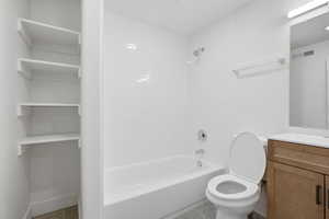 Full bath with vanity, tile patterned floors, bathtub / shower combination, and a closet