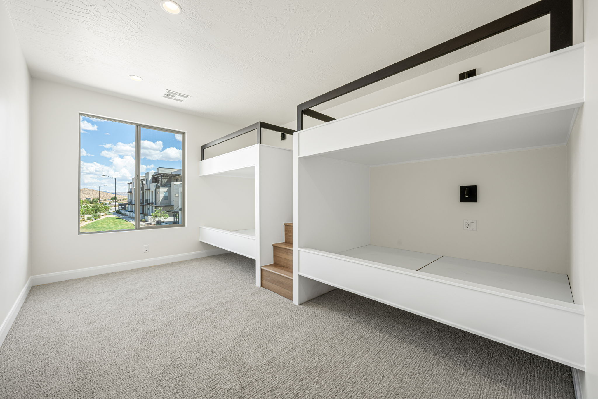 Built-in bunk beds with integrated wood-finish stairs provide efficient sleeping arrangements