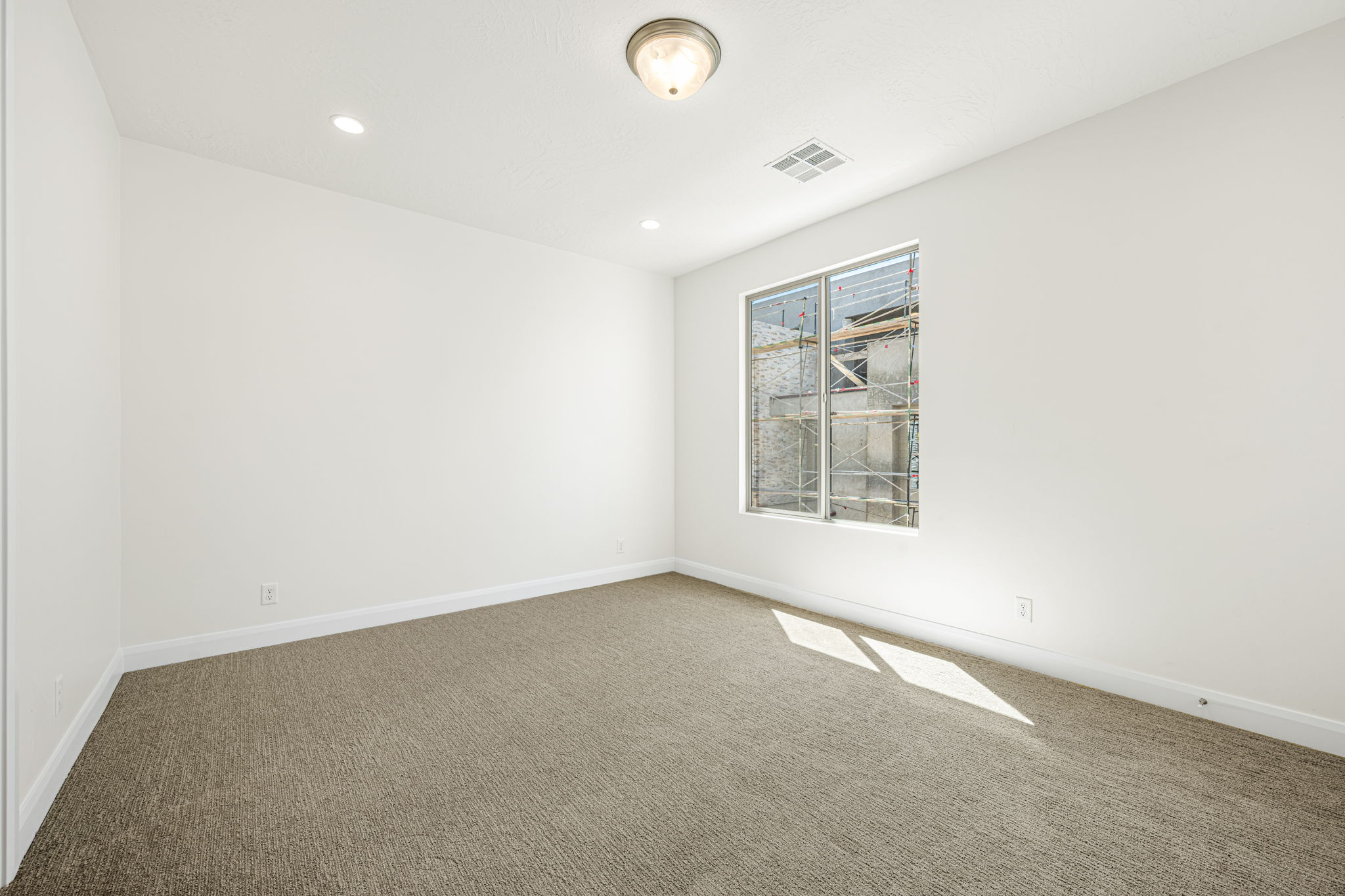 Neutral-toned carpet flooring with white baseboards and walls