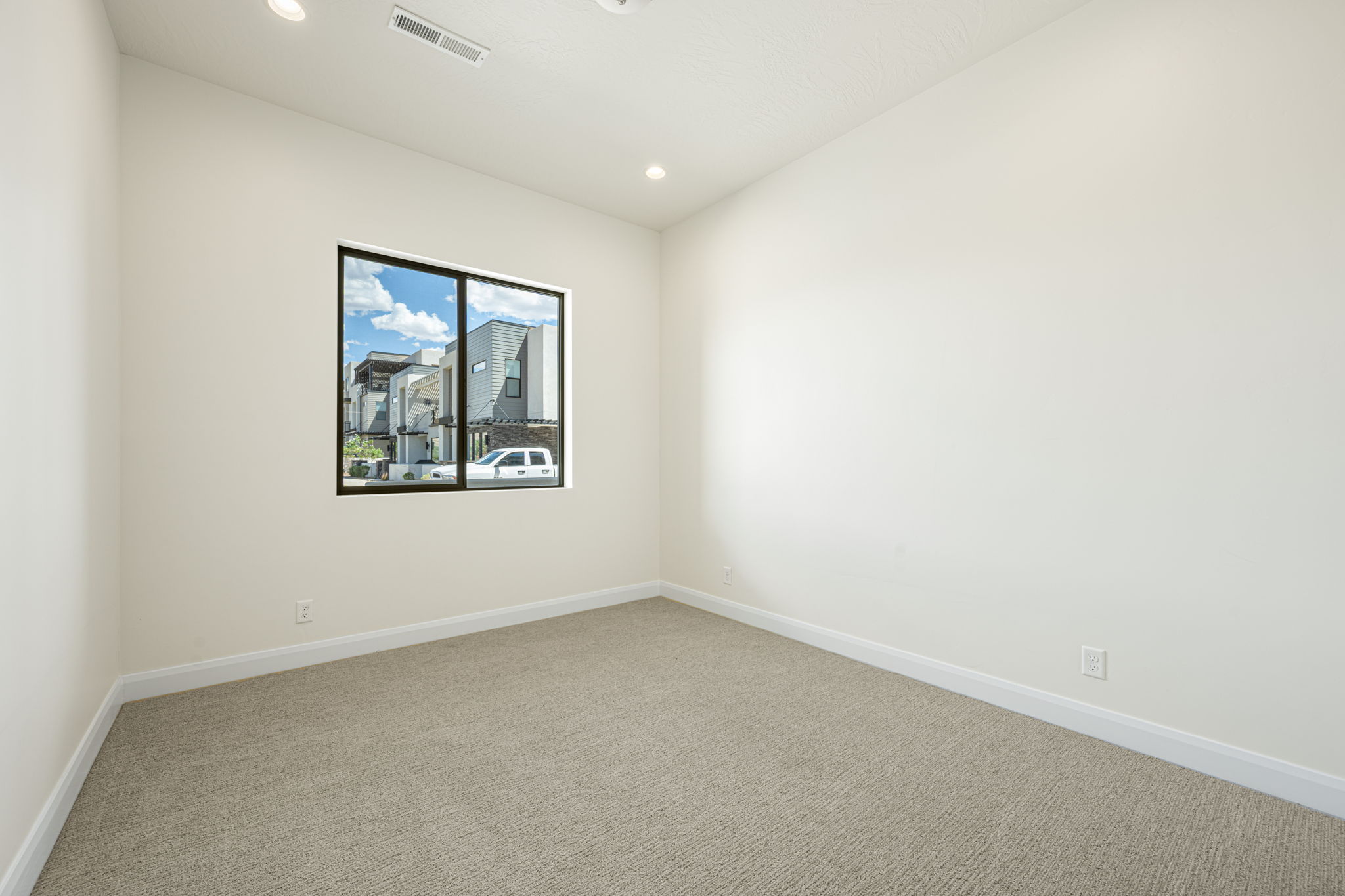 Neutral-toned room with light beige carpeting and white baseboards