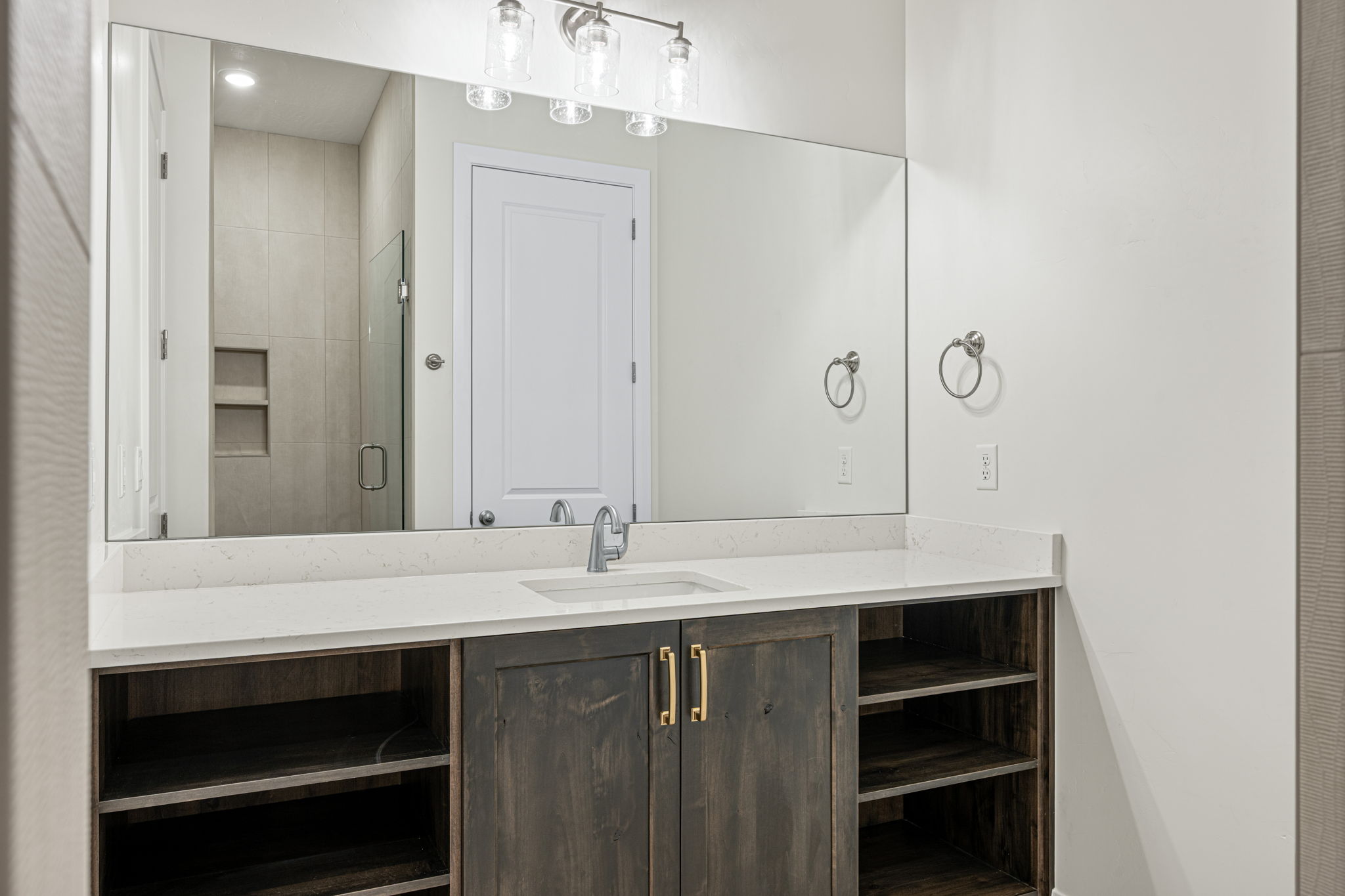 Bathroom vanity with a rectangular undermount sink, a chrome faucet, and a light-colored countertop
