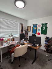 Office with dark carpet and baseboards