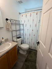 Full bath featuring vanity, a shower with shower curtain, and dark wood-type flooring