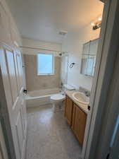 Bathroom with vanity, tub / shower combination, a textured ceiling, and light floors