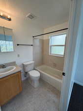 Full bathroom featuring vanity, a textured ceiling, and  shower combination