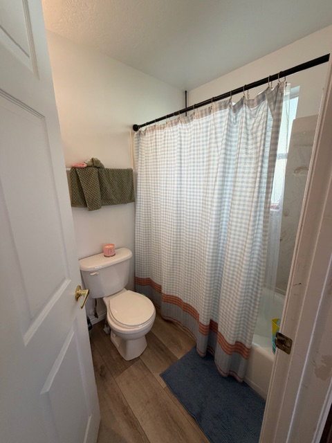 Bathroom with light wood finished floors and shower / tub combo
