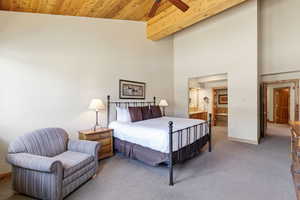 Bedroom with carpet, ensuite bath, a ceiling fan, and a high wooden ceiling