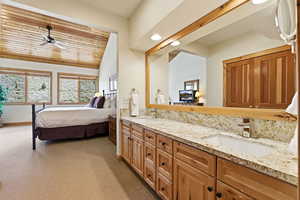 Ensuite bathroom featuring a vaulted wooden ceiling, double vanity, light colored carpet, ceiling fan, and recessed lighting