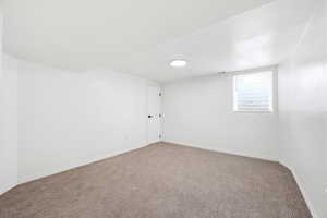 Unfurnished room with baseboards and carpet