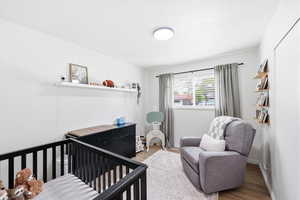 Bedroom featuring a crib and light wood-style flooring