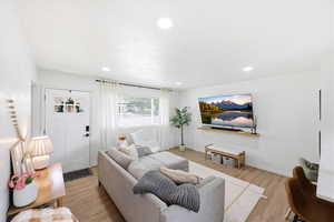 Living room with light wood-style flooring and recessed lighting