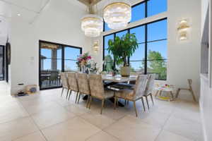Dining area featuring a high ceiling, a chandelier, and light tile patterned floors