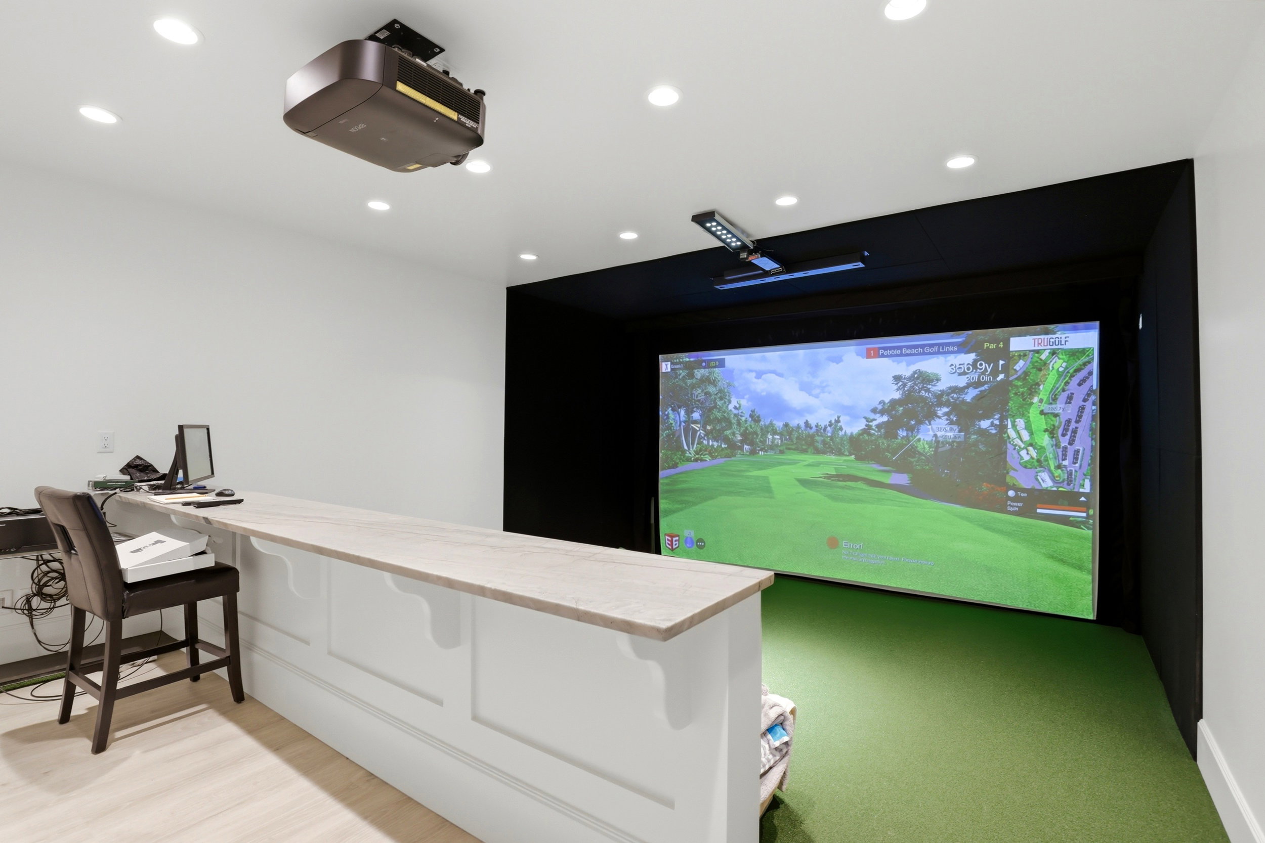 Cinema room featuring golf simulator and recessed lighting