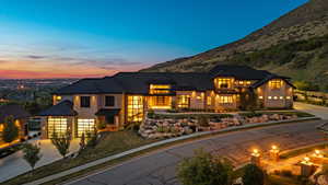 View of front of house featuring driveway, stone siding, and an attached garage