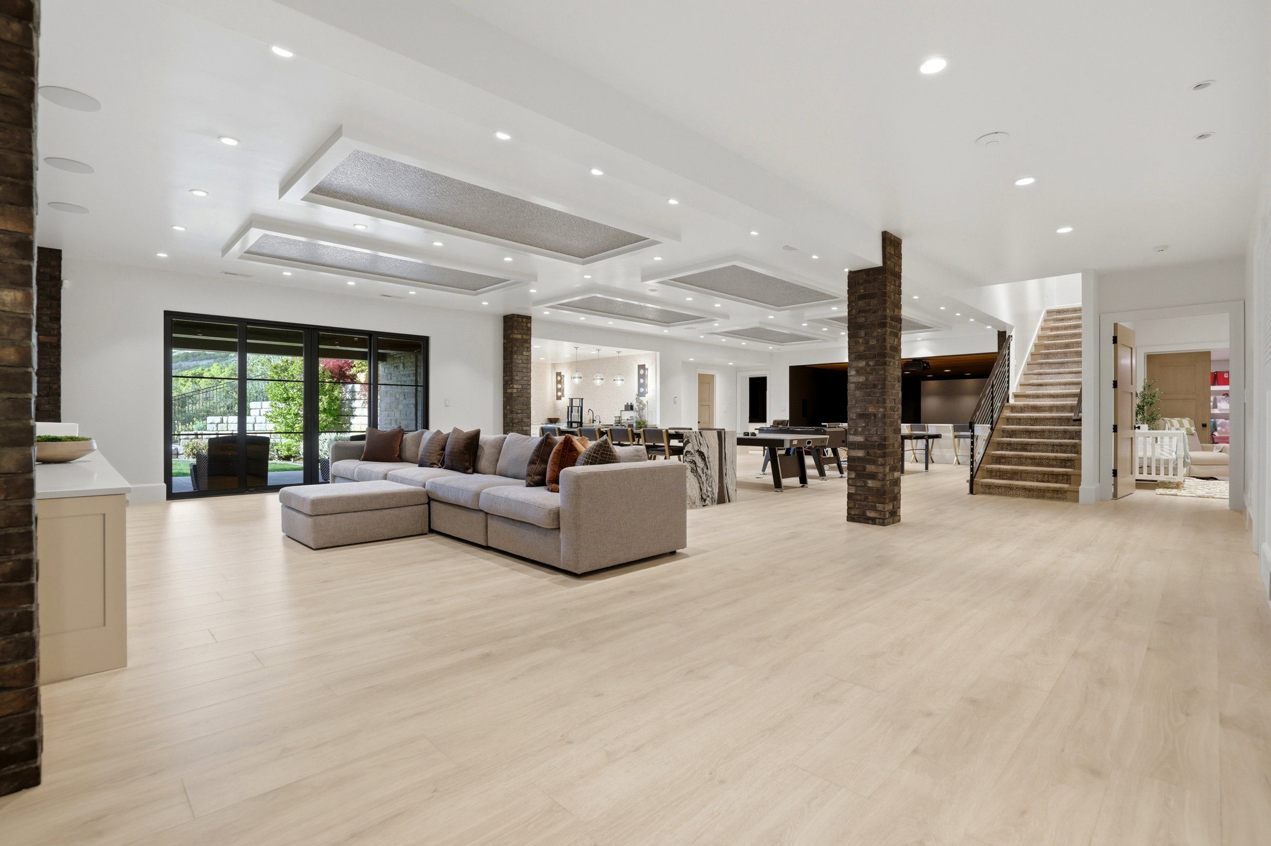 Living area featuring a raised ceiling, light wood-type flooring, and recessed lighting