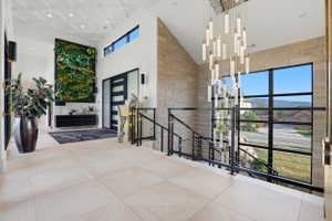 Corridor featuring a high ceiling, an upstairs landing, and recessed lighting