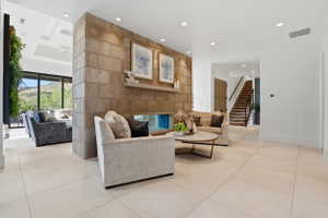 Living room with light tile patterned floors and recessed lighting